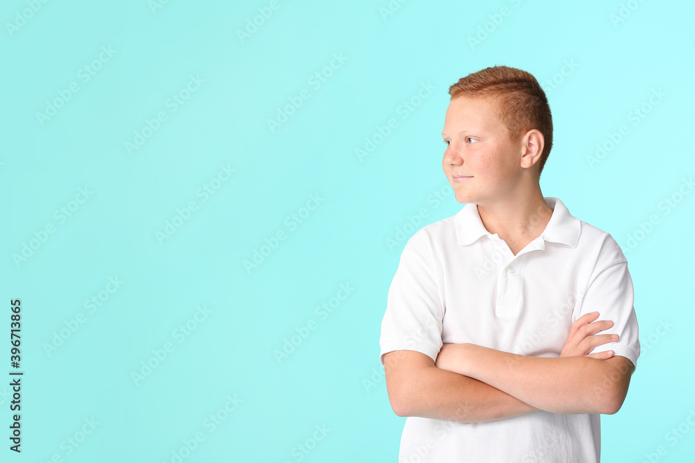 Smiling teenage boy with crossed arms on color background Smiling teenage boy with crossed arms on color background