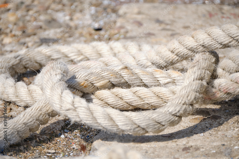 Abstract Background texture of thick, strong rope on the harbor quay. Lies on the floor