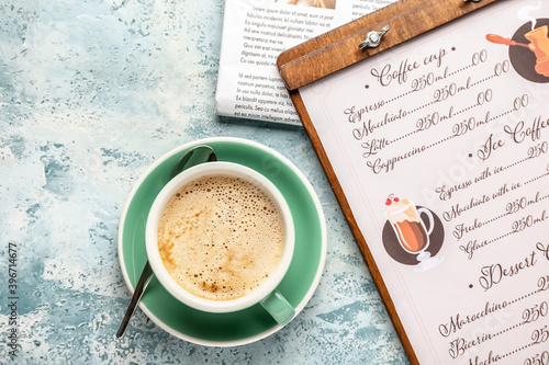 Cup of hot coffee and newspaper on table in cafe