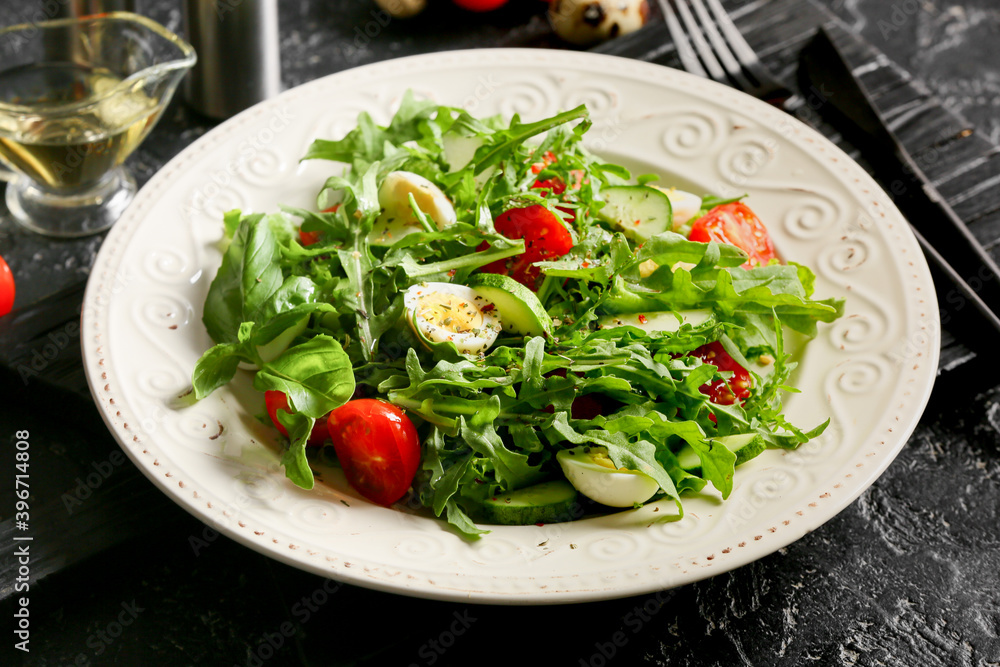 Plate with tasty arugula salad and ingredients on dark background Plate with tasty arugula salad and ingredients on dark background