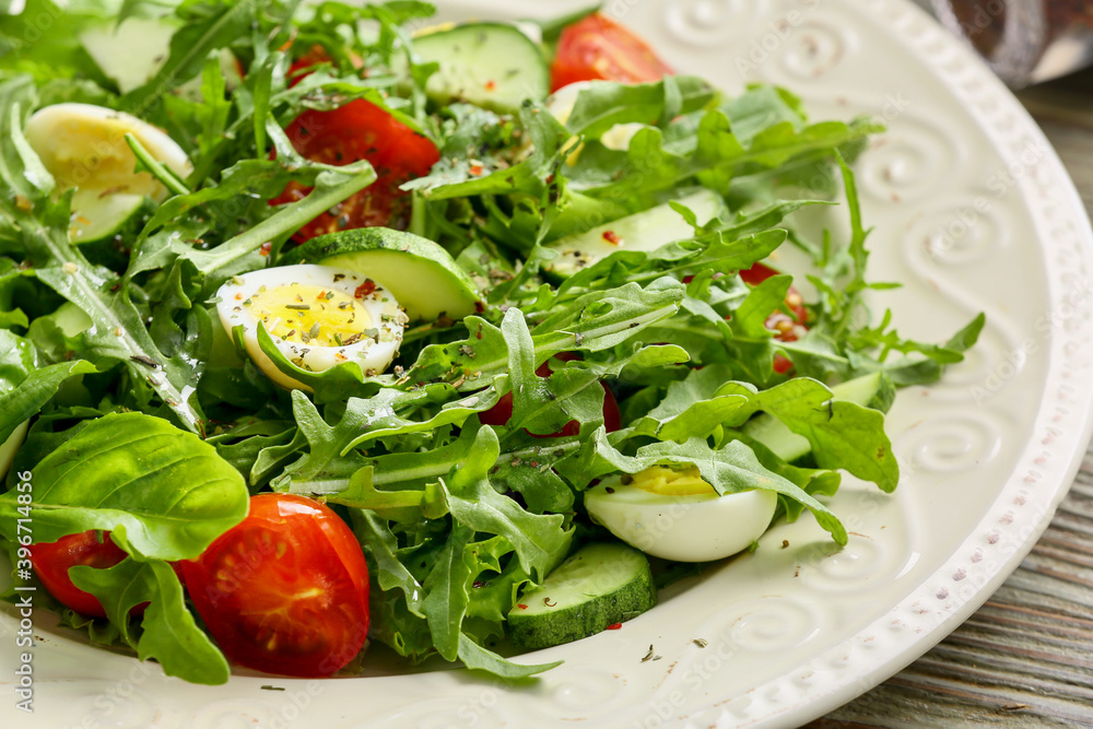 Plate with tasty arugula salad on wooden table Plate with tasty arugula salad on wooden table