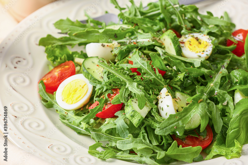 Plate with tasty arugula salad on light table Plate with tasty arugula salad on light table