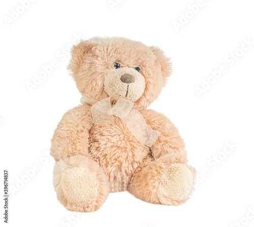 Furry light brown teddy bear toy wearing beige ribbon butterfly knot isolated on white background