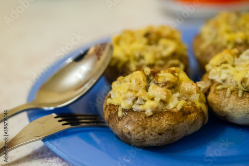 Grilled mushrooms stuffed with cheese on blue plate