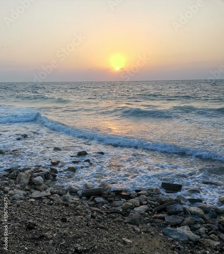 Rocks on sea waves and beautiful sunset