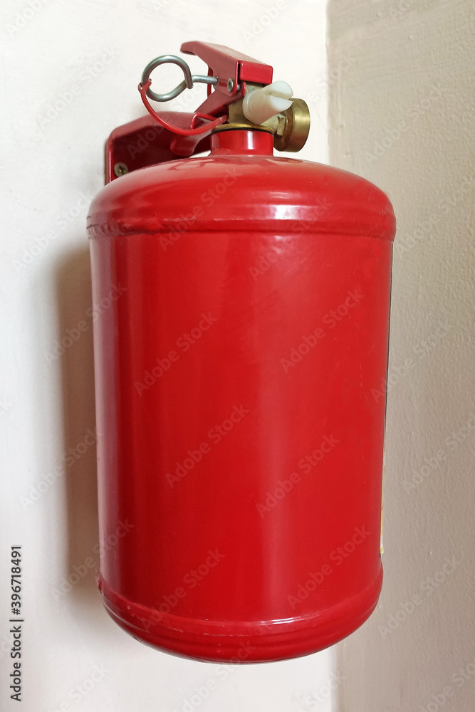 Red fire extinguisher mounted to a gray wall. Fire extinguishers available in fire emergencies. High quality photo Red fire extinguisher mounted to a gray wall. Fire extinguishers available in fire emergencies. High quality photo
