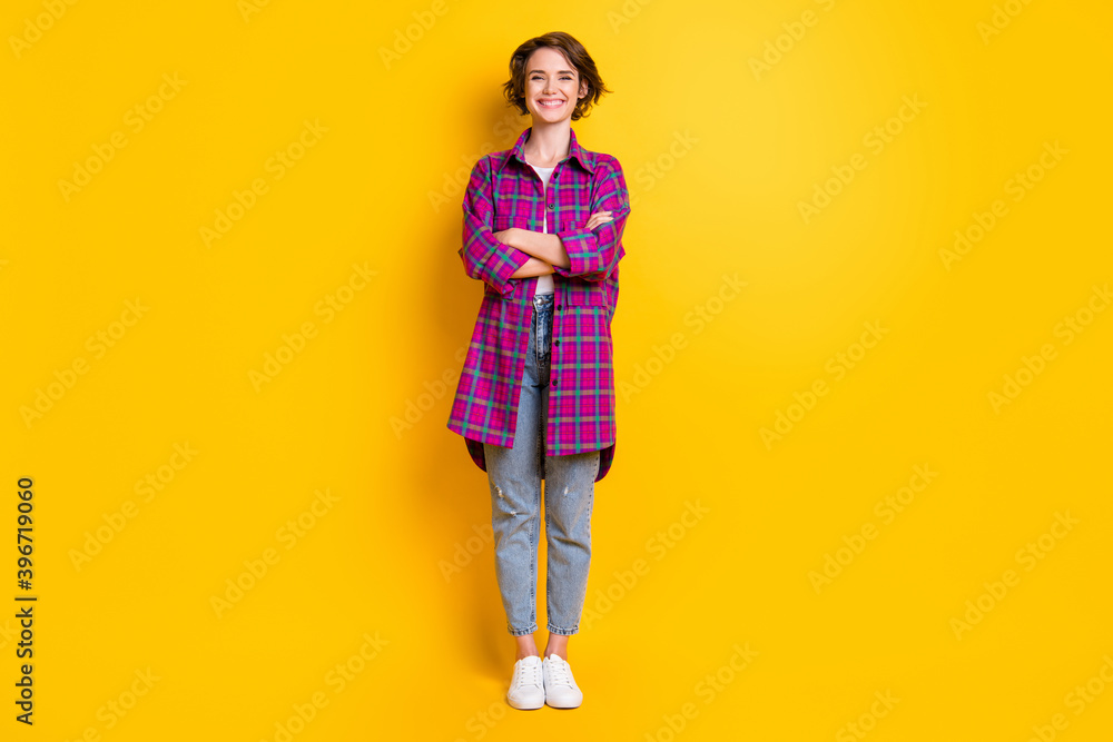 Full size photo of pretty charming cheerful happy young woman wear jeans plaid shirt isolated on yellow color background Full size photo of pretty charming cheerful happy young woman wear jeans plaid shirt isolated on yellow color background