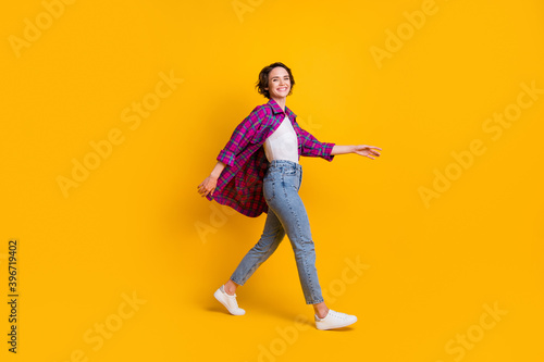 Full body profile side photo of charming young lady go walk free time smile isolated on yellow color background