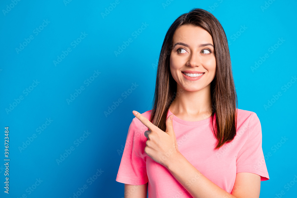 Photo portrait of curious female student showing looking at blank space smiling isolated on bright blue color background Photo portrait of curious female student showing looking at blank space smiling isolated on bright blue color background