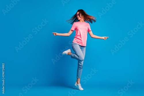 Fototapeta Naklejka Na Ścianę i Meble -  Full length body size photo of cheerful smiling girl dancing standing tiptoes throwing hair isolated on bright blue color background
