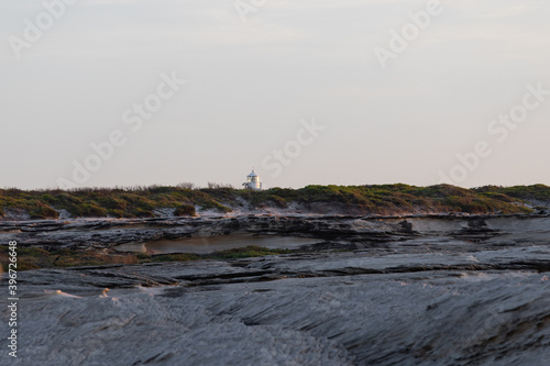 A small lighthouse within the cliff coastline.