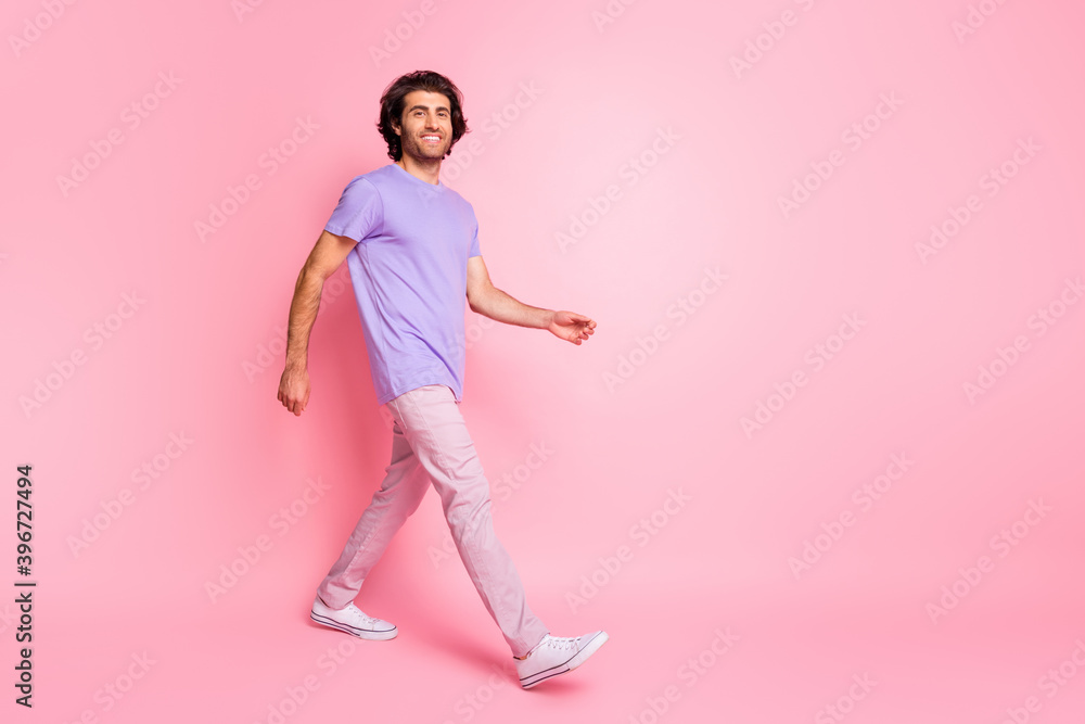Full body photo of walking person smile relaxed wear magenta clothing isolated on pink color background