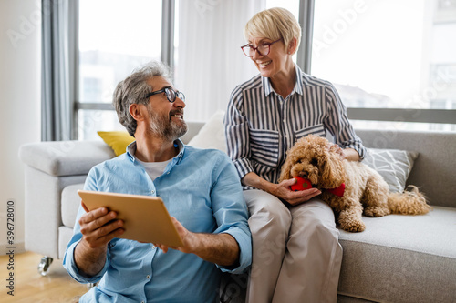 Happy smiling mature couple using digital tablet at home