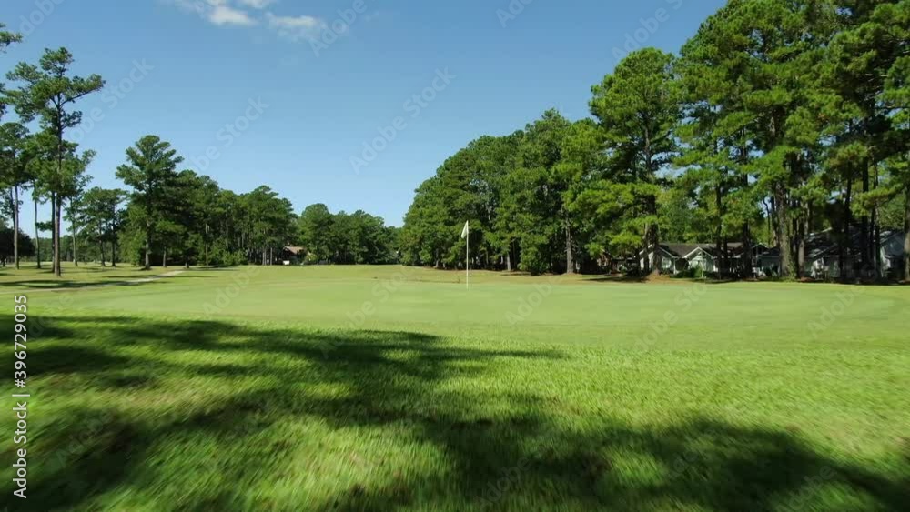 Golf course, oak trees, greens and golf carts with people playing on 18 hole course in Georgetown, South Carolina Golf course, oak trees, greens and golf carts with people playing on 18 hole course in Georgetown, South Carolina