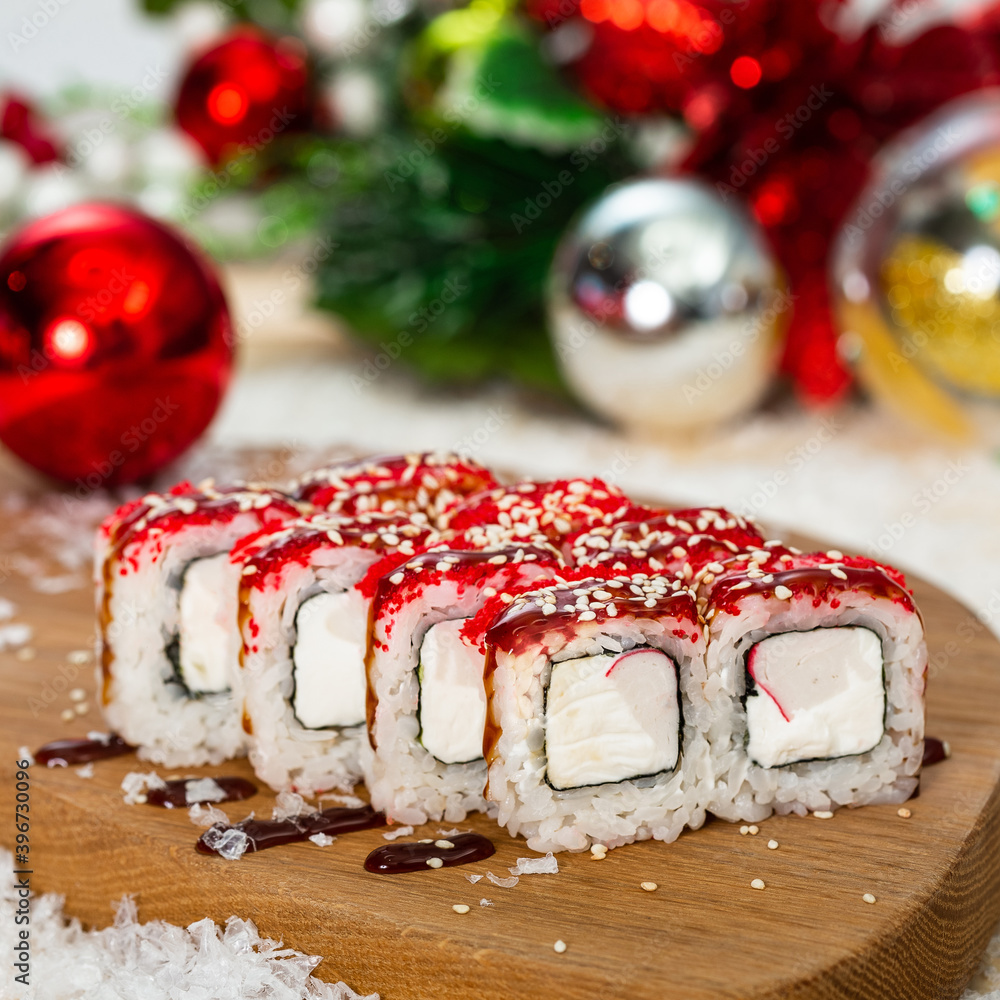Happy New Year and Christmas celebrations. Original design of the table in the dining room with freshly prepared japanese cuisine sushi and rolls. Christmas eve