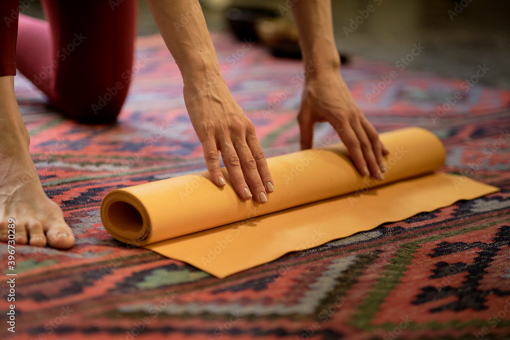 Woman rolling her mat after a yoga class