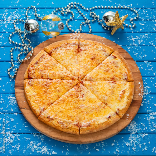Obraz na płótnie Pizza. Happy New Year and Christmas celebrations. Original design of the blue wooden table in the dining room with freshly prepared Pizza Margarita. Christmas eve w salonie