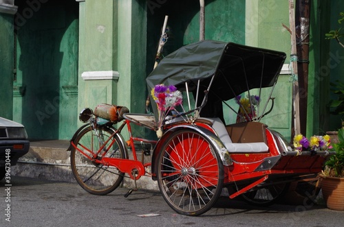 Rickshaw parked empty along the side of the road in George Town, Penang, Malaysia