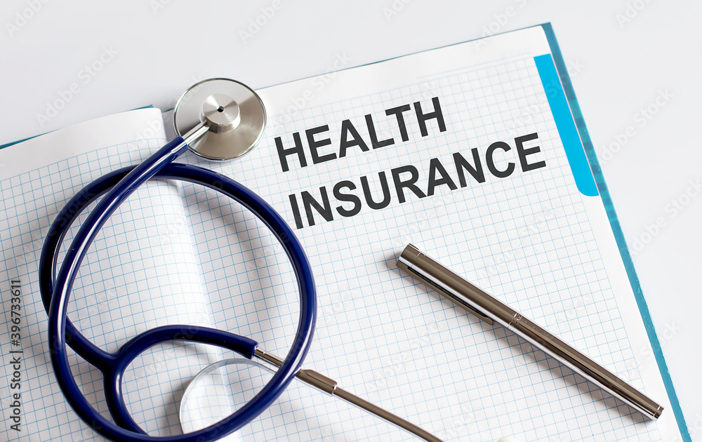 Paper with text Health insurance on table with stethoscope Paper with text Health insurance on table with stethoscope