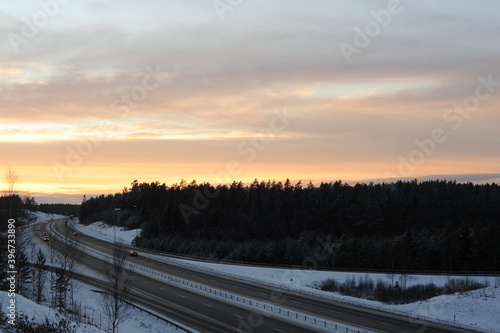 Winter driving on a snowy highway road during dusk and sunset in Sweden, Europe, Scandinavia