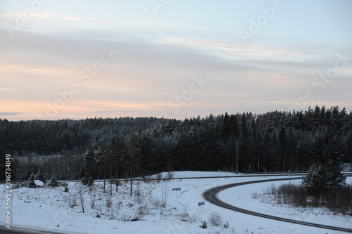 Winter driving on a snowy highway road during dusk and sunset in Sweden, Europe, Scandinavia