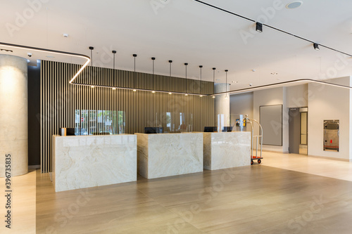 Fototapeta Interior of a hotel lobby with reception desks with transparent coronavirus guar