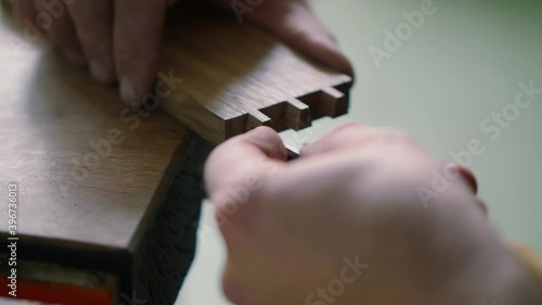 close up. a woodworker carves a dovetail joint into an oak plank with a wood chisel. carpentry, craftsmanship, handicrafts. the sounds of carpentry tools