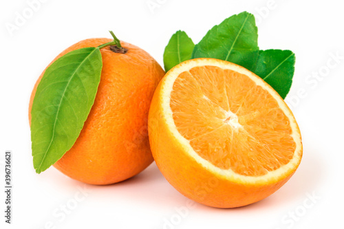 Orange fruit with orange slices and leaves isolated on white background.