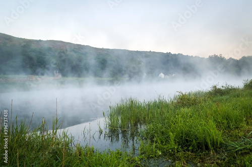 In a river landscape with nature morning with fog