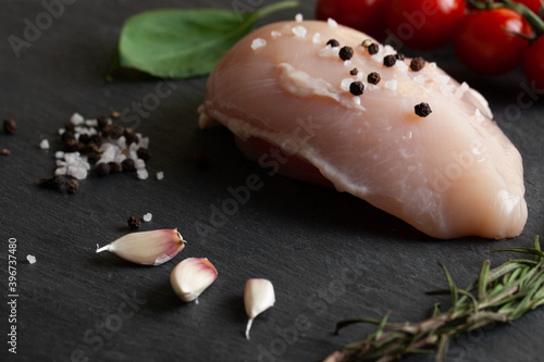 Raw chicken fillet on a concrete table with spices. 