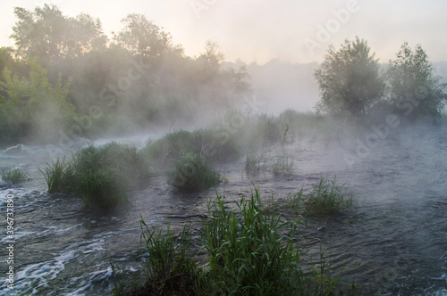 Obraz na płótnie Rough river with fast-flowing in the fog and mist on the background w salonie