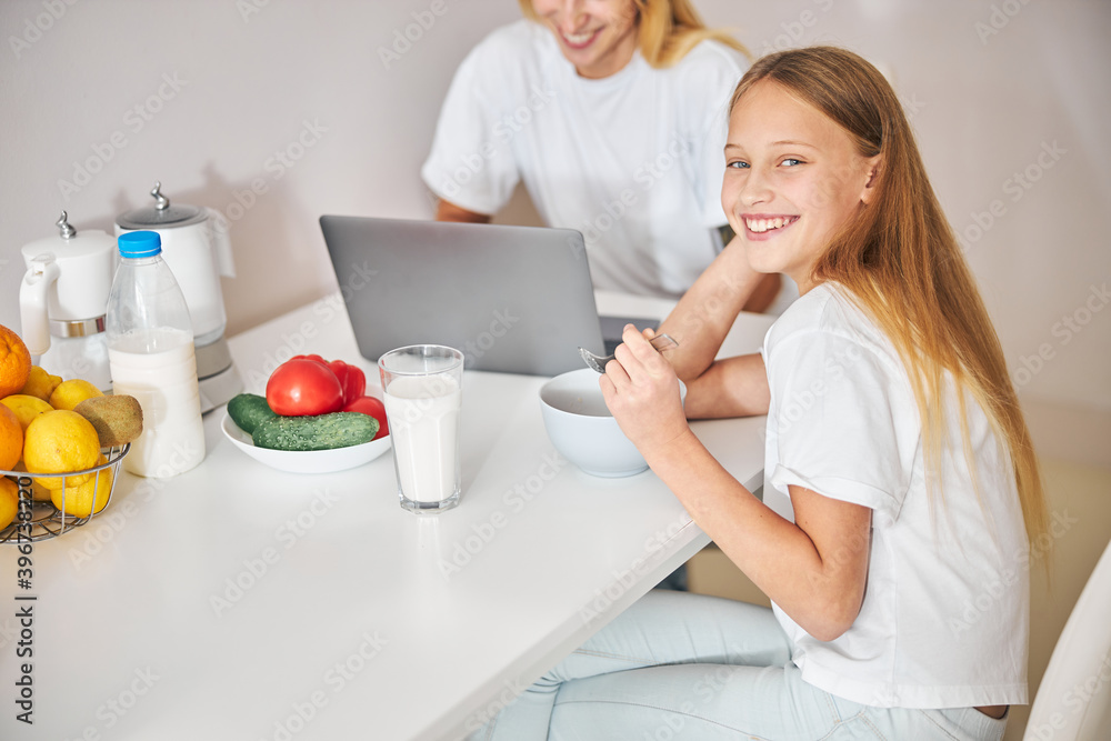 Joyous teen and her busy female parent in the kitchen Joyous teen and her busy female parent in the kitchen