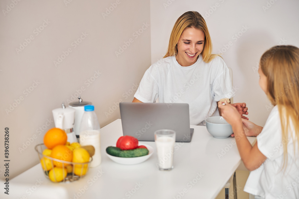 Girl sharing her breakfast with her mother