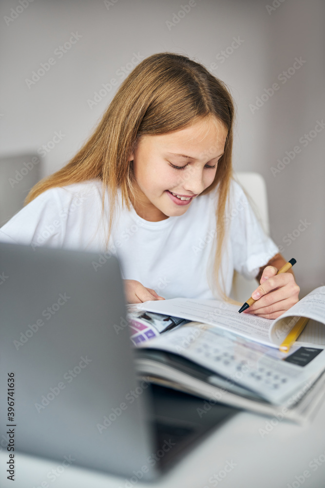 Hard-working minor student filling in the exercise Hard-working minor student filling in the exercise