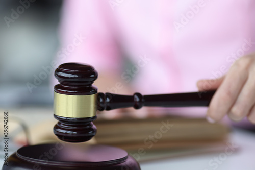 Wall Mural Female hand holds judge's wooden gavel closeup