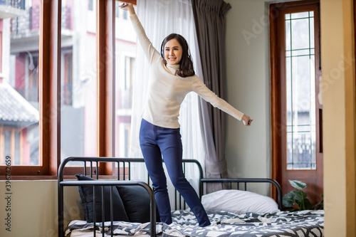 Asian woman dancing on the bed.