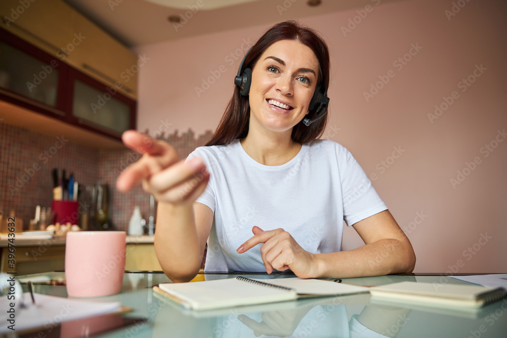 Woman pointing her finger at the camera with a smile Woman pointing her finger at the camera with a smile