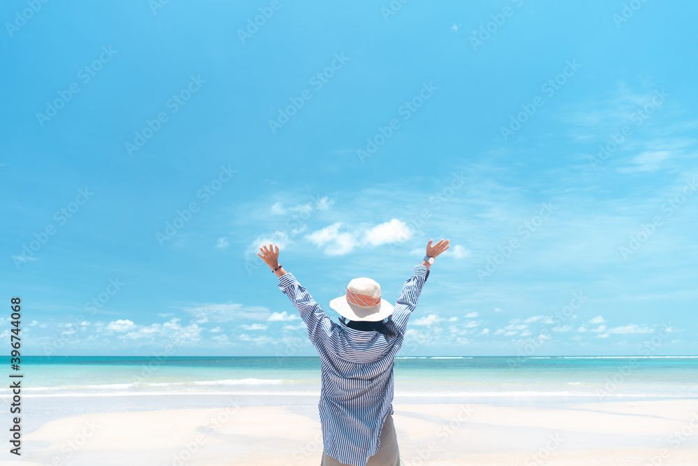 Happy woman raise hand up at tropical beach with blue sky background. Travel vacation and freedom feel good concept. Happy woman raise hand up at tropical beach with blue sky background. Travel vacation and freedom feel good concept.