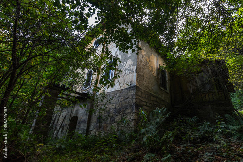 large abandoned yellow house in the forest