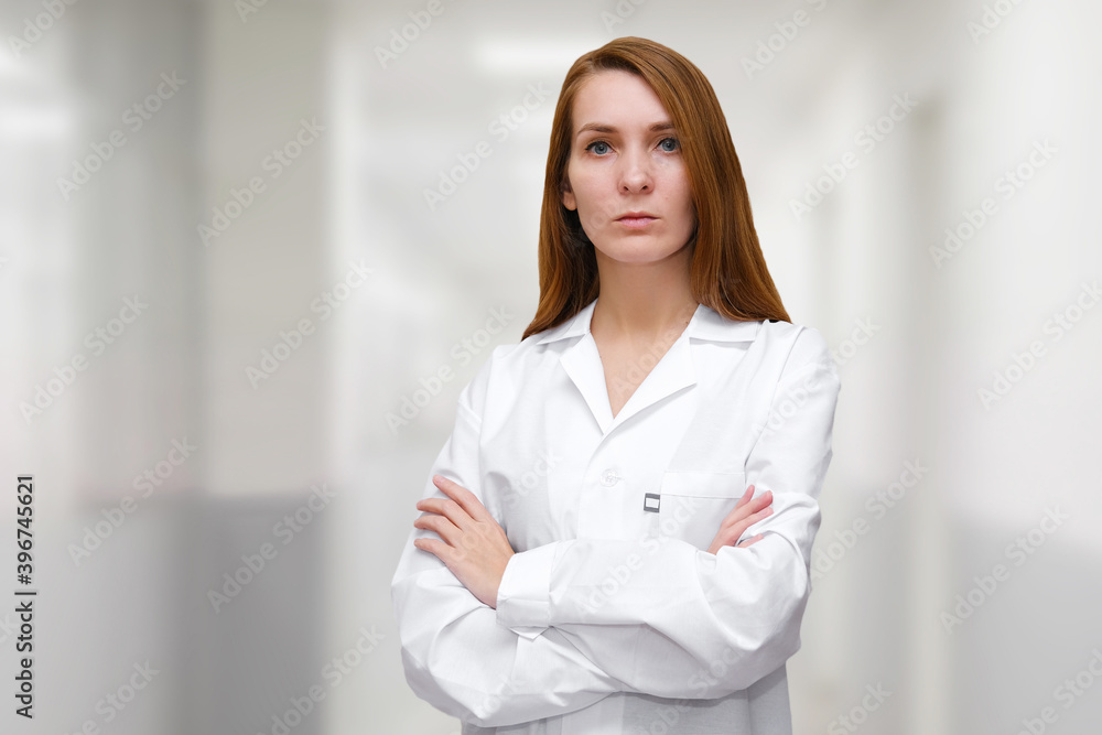 Doctor in white robe stands in the hall of the hospital. Doctor treating for a coronavirus infection. Doctor in white robe stands in the hall of the hospital. Doctor treating for a coronavirus infection.