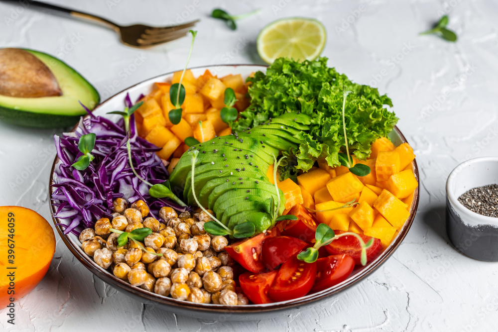 Healthy vegetarian food concept. Buddha bowl vegetarian, vegan dish with avocado, tomato, red cabbage, chickpea, fresh lettuce salad, pumpkin, persimmon