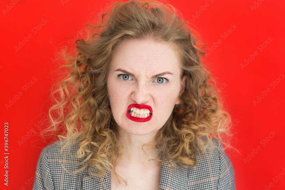 Screaming, hate, rage. Emotional angry woman is angry on red studio background. Emotional, young face, web banner. Expressive facial emotions Screaming, hate, rage. Emotional angry woman is angry on red studio background. Emotional, young face, web banner. Expressive facial emotions