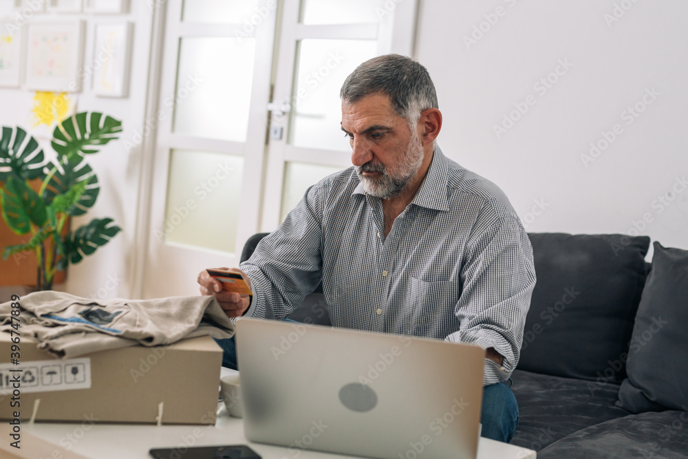 middle aged man shopping online from his home middle aged man shopping online from his home