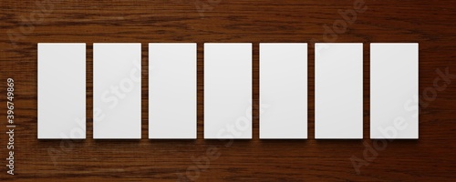 Collage von sieben leeren weißen Bilderrahmen vor einem Holzhintergrund