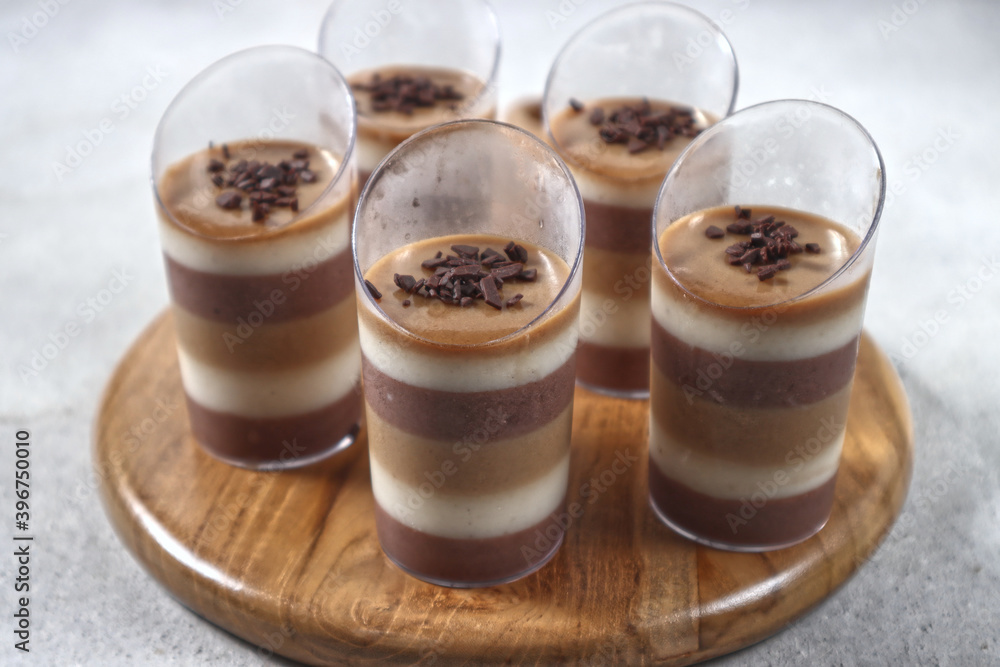 Triple layered pudding made from chocolate, vanilla and coffe in glass. Triple layered pudding made from chocolate, vanilla and coffe in glass.