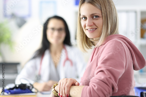 Portrait of woman and doctor in medical office.