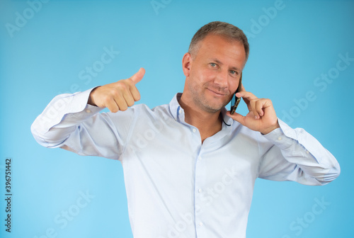 young business man listening on a phone on a blue background