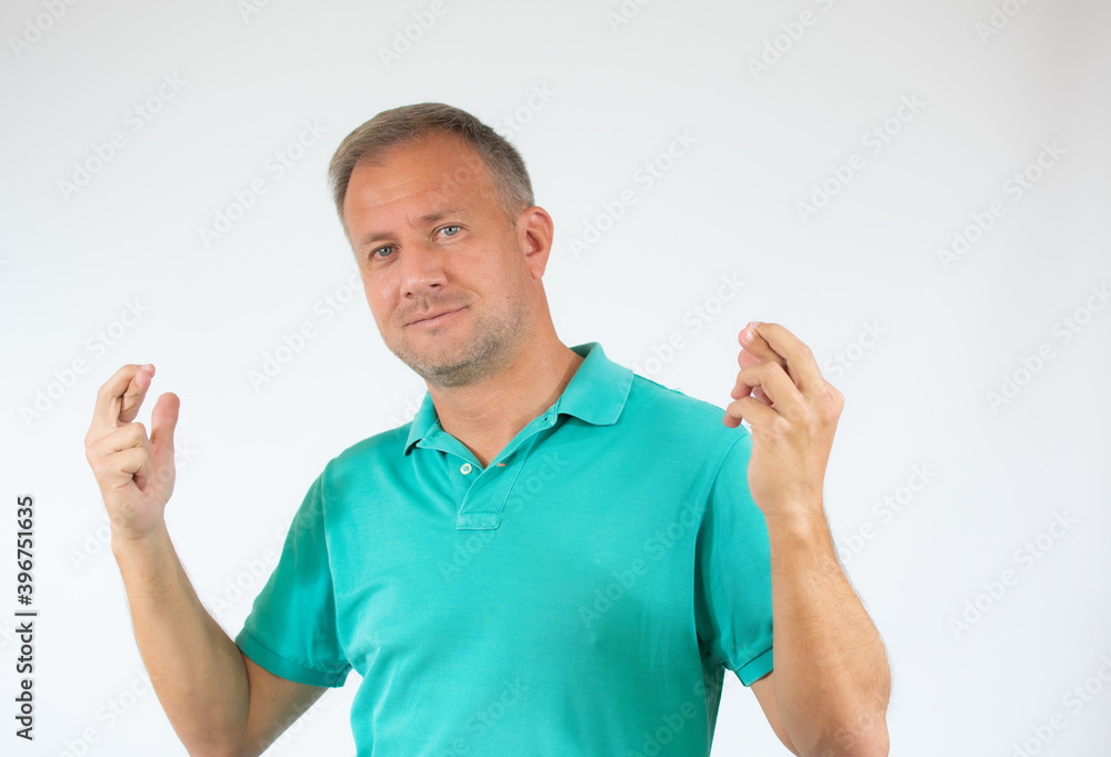 A portrait of a young man with crossed fingers over white background. A portrait of a young man with crossed fingers over white background.