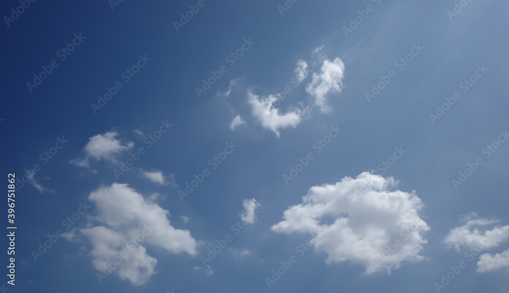 Beautiful clear blue sky with little group of clouds, some ray of light from the right edge of picture Beautiful clear blue sky with little group of clouds, some ray of light from the right edge of picture