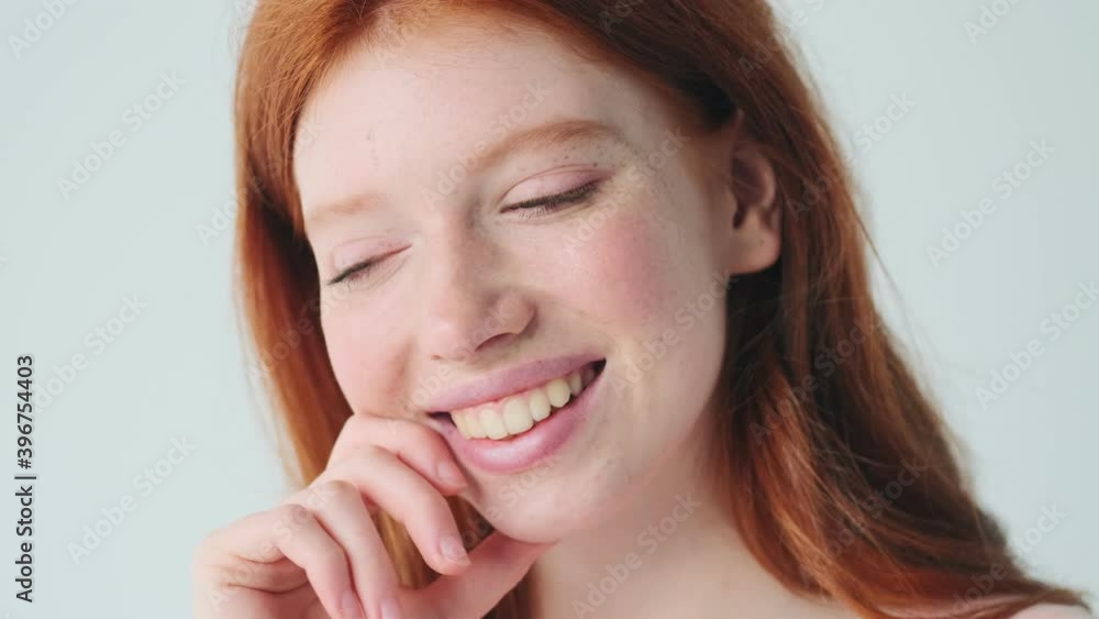 Cute cheery redhead girl posing isolated over white wall background Cute cheery redhead girl posing isolated over white wall background